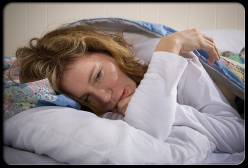 Unhappy, Exhausted Woman with Chronic Fatigue Syndrome lying in bed.