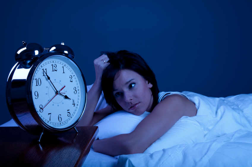 Tired Woman with Insomnia in Bed Starring at Clock