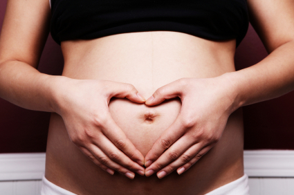 Pregnant Woman with Hands forming Heart over Womb